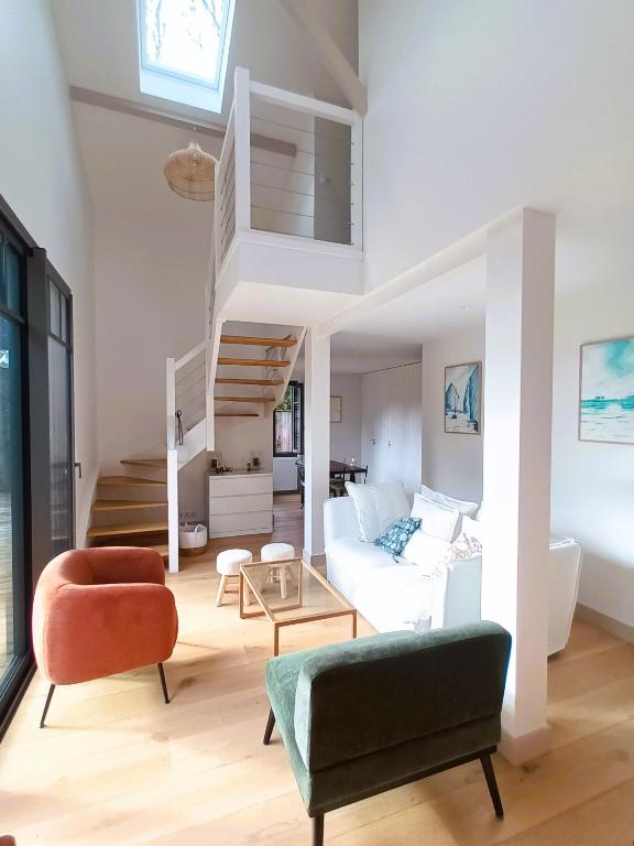 - un salon avec un canapé blanc et des escaliers dans l'établissement Arcachon le Moulleau maison moderne 3 chambres climatisation - 250m de la plage, à La Teste-de-Buch