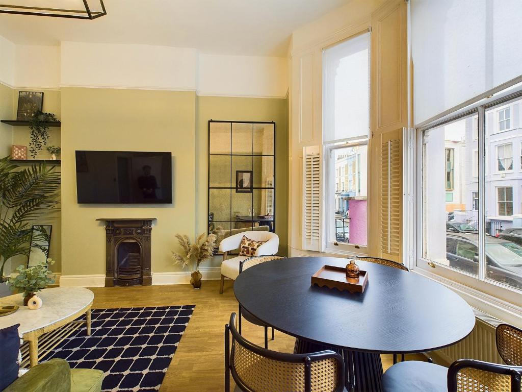 sala de estar con mesa, sillas y chimenea en Be London - Notting Hill Apartments, en Londres