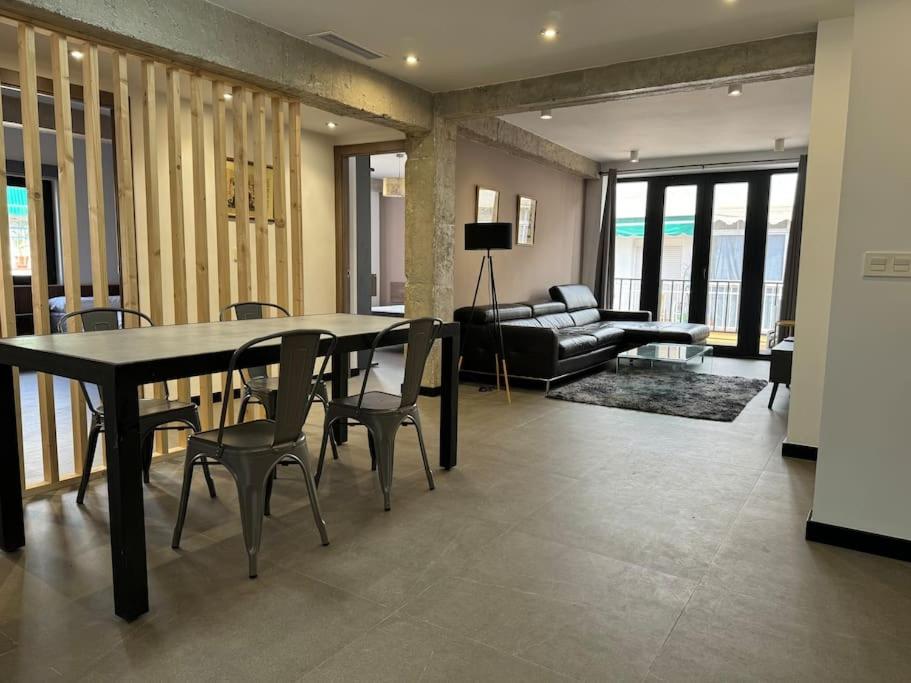 Elegante piso reformado a 1km del centro في غرناطة: غرفة معيشة مع طاولة وكراسي وأريكة