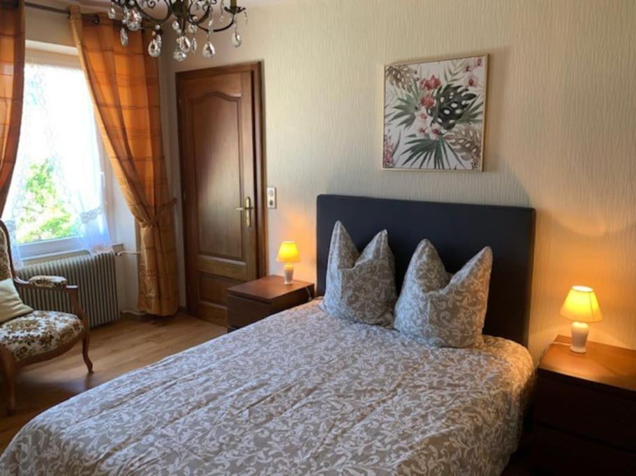 een slaapkamer met een groot bed met kussens erop bij ALSACE GITE 5 PERSONNES - 3 CHAMBRES - 2 SDB in Buhl