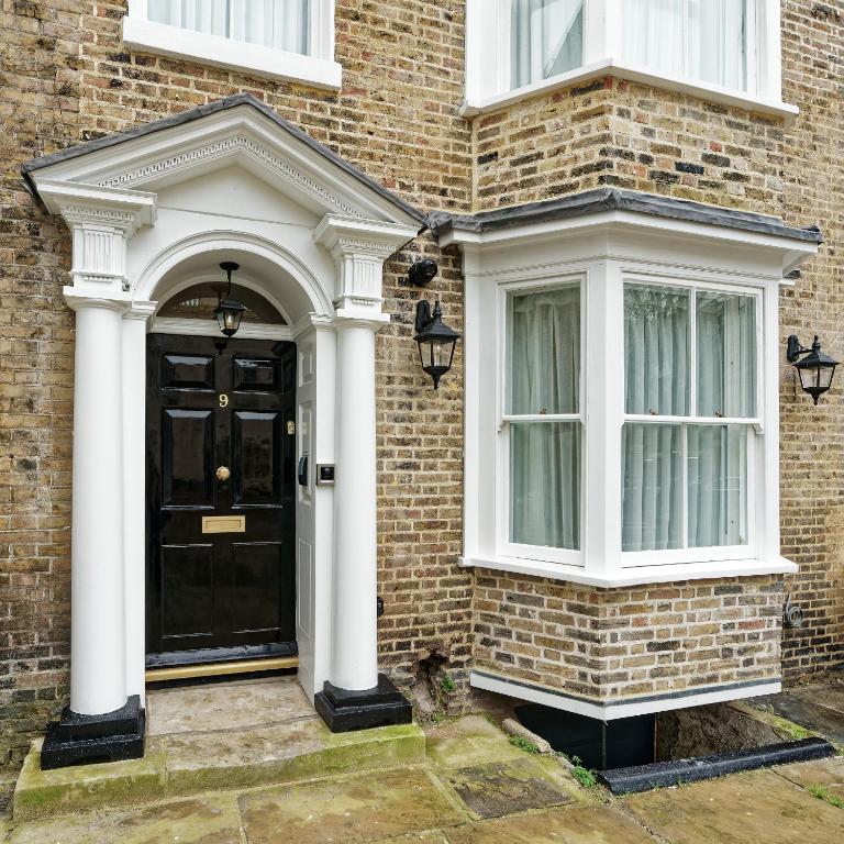 a black door on the side of a brick house at Old Town House by Ezestays in Margate