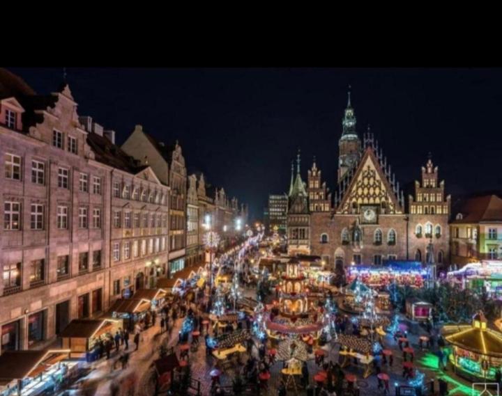 a christmas market in the middle of a city at night at Centrum flats Free Parking in Wrocław