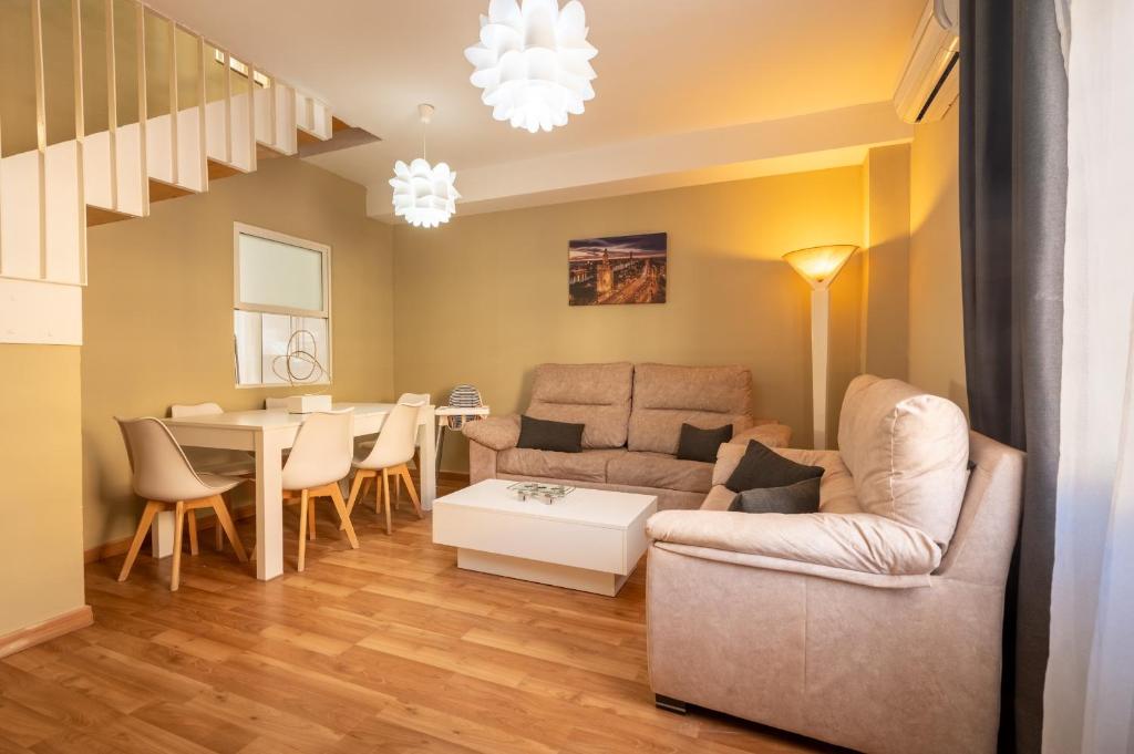 uma sala de estar com um sofá e uma mesa em Casa unifamiliar em Sevilha