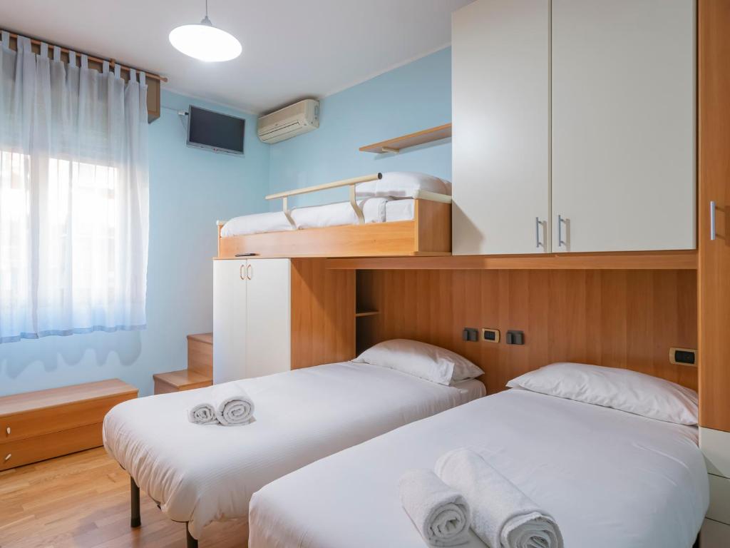 2 camas en una habitación con paredes azules en I Host Apartment - Abeti 15 en Baggio