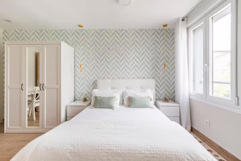 1 dormitorio con 1 cama blanca grande y 2 almohadas en Apartamento El Toisón de Oro 11 Garaje gratis, en Bilbao
