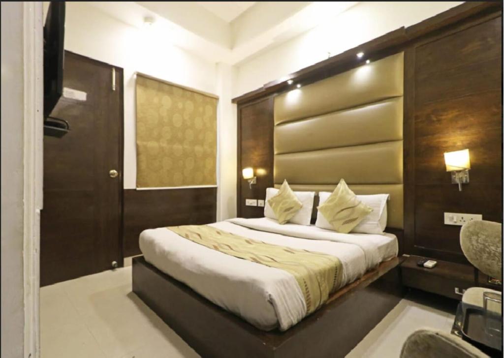 Un dormitorio con una cama grande con cabecero de madera. en HOTEL AEROPATH INN, en Nueva Delhi