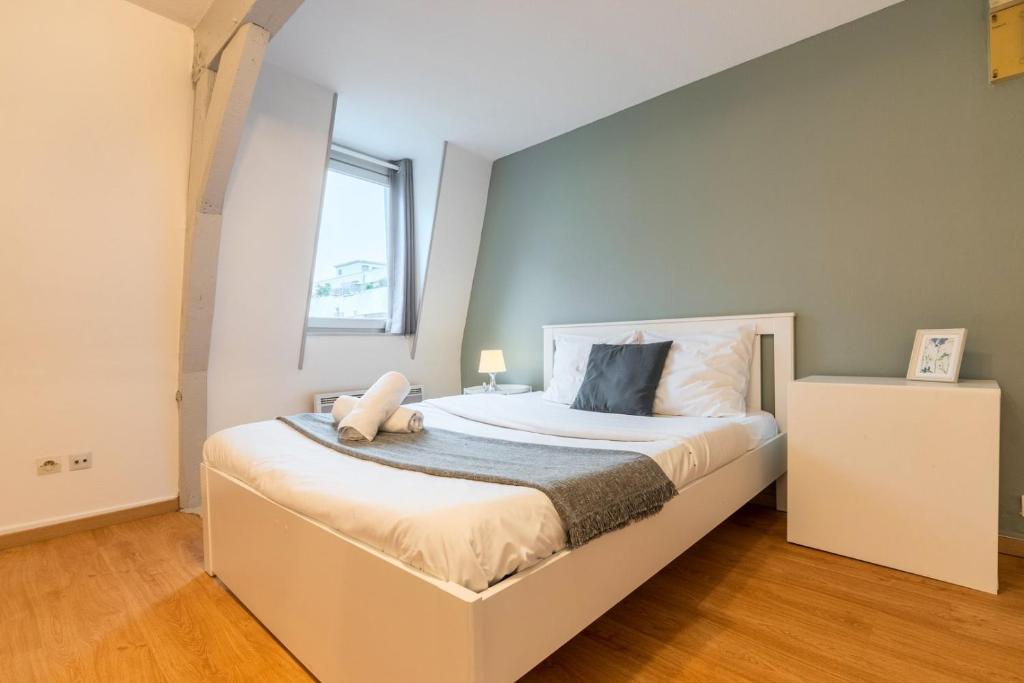 une chambre avec un grand lit blanc avec une fenêtre dans l'établissement Functional studio and equipped, à Lille