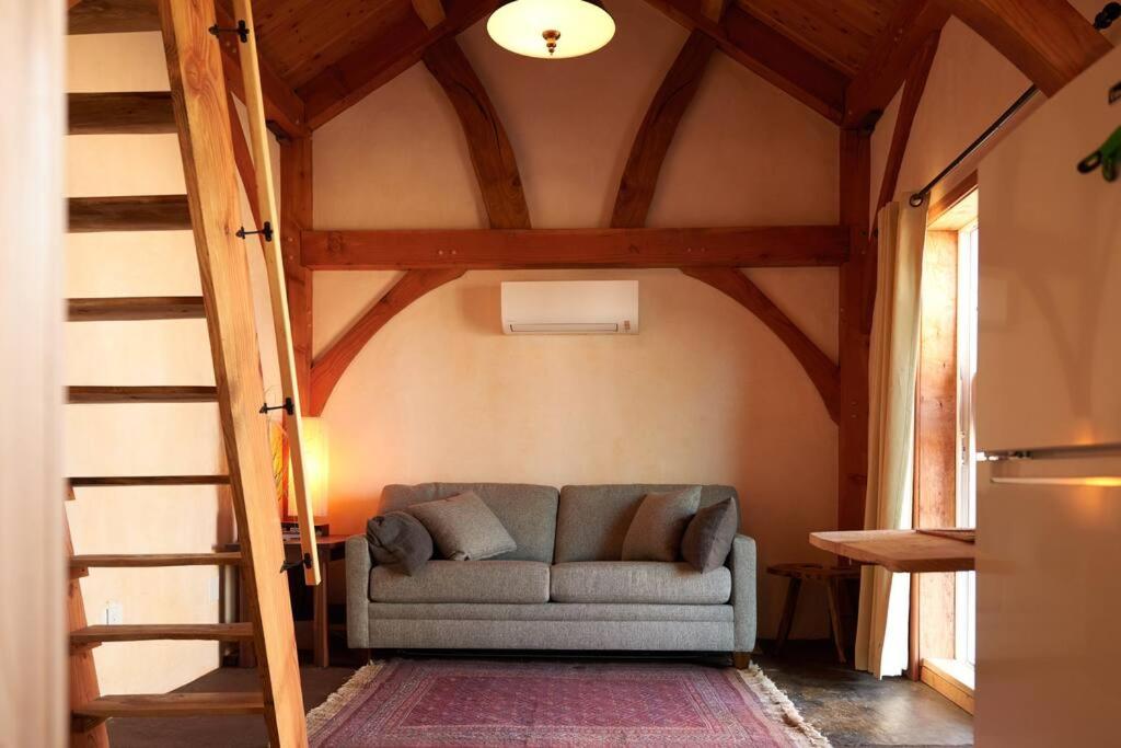 a couch in a living room with a wooden ceiling at Timber frame guesthouse in NE Portland in Portland