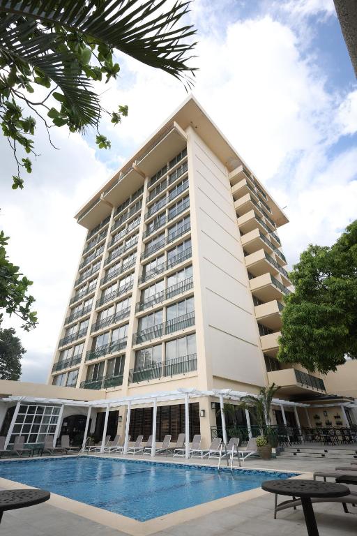 - un grand bâtiment avec une piscine en face dans l'établissement Courtleigh Hotel & Suites, à Kingston