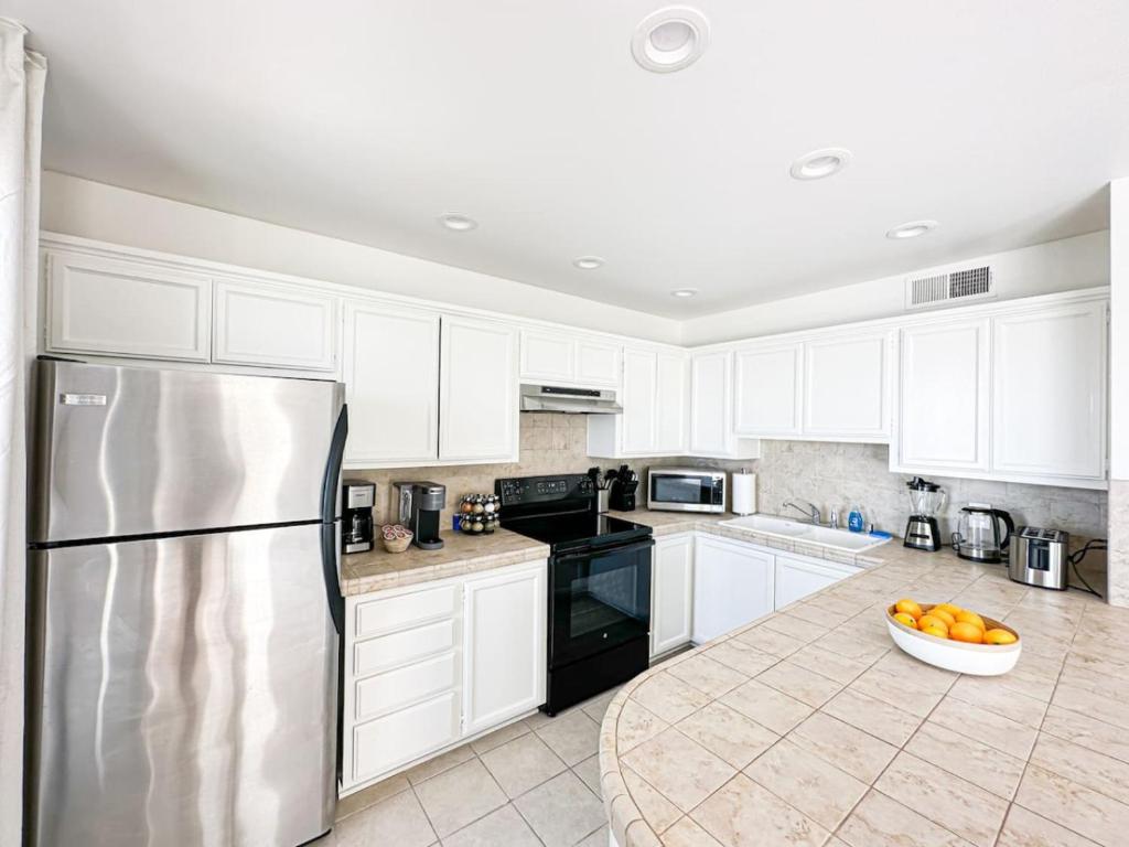 a kitchen with white cabinets and a stainless steel refrigerator at 1 BR exceptional house PCHL-TOP in Topanga