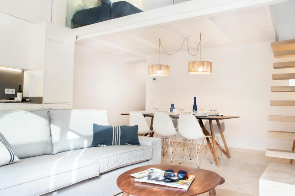 a living room with a white couch and a table at YourHouse Iris House in Colonia de Sant Pere