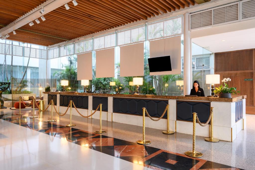 Eine Frau steht in einer Lobby mit einer Bar. in der Unterkunft Royal Beach Eilat by Isrotel Exclusive in Eilat