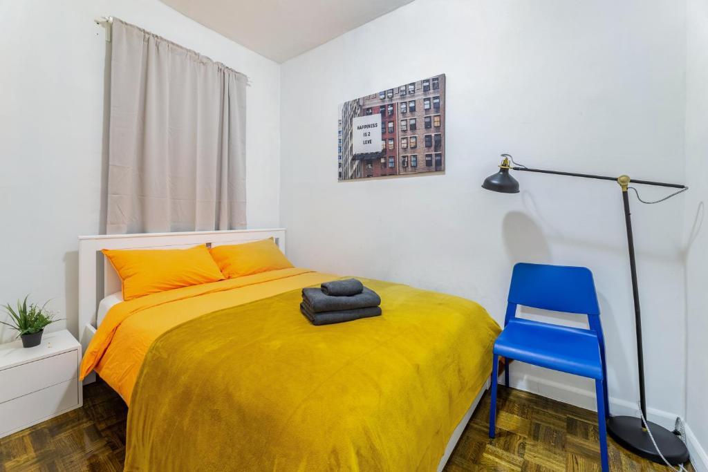 a bedroom with a yellow bed and a blue chair at Modern NY Style 2BD Apartment in Upper East Side Manhattan in New York