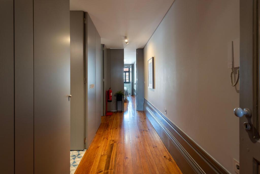 a hallway with wooden floors and white walls at Cedofeita's Blue House in Porto