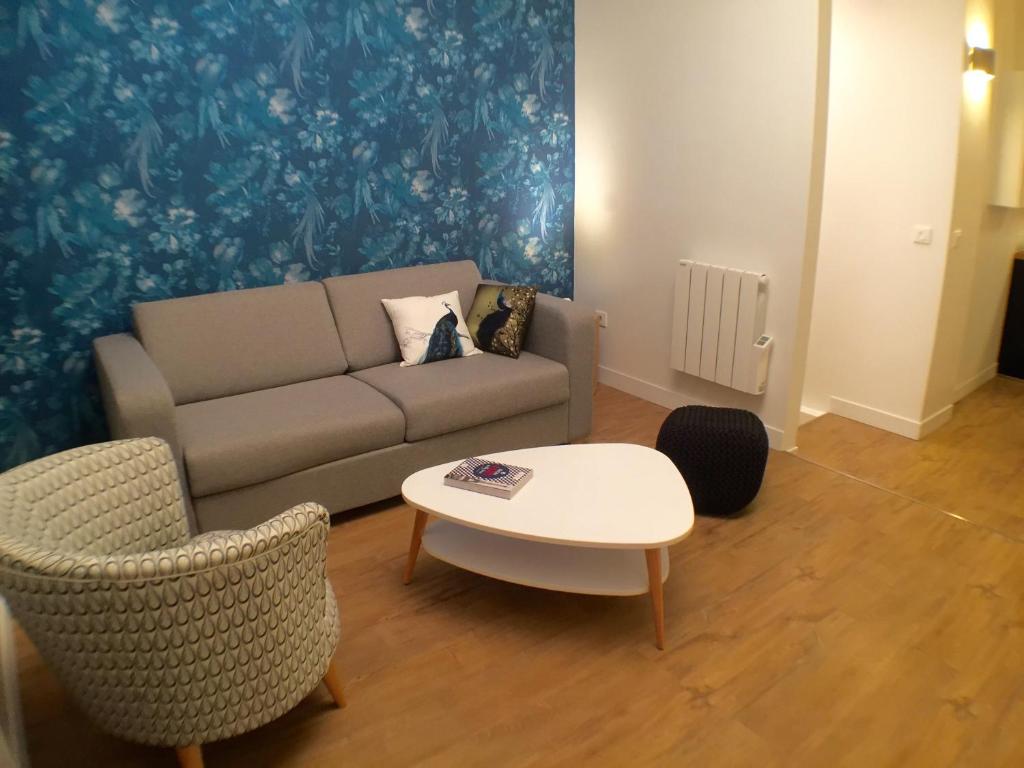 a living room with a couch and a table and chairs at The Blue House in Paris