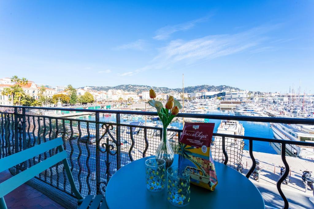 une table sur un balcon avec vue sur un port dans l'établissement Le Saint-Pierre PET231 2P, à Cannes
