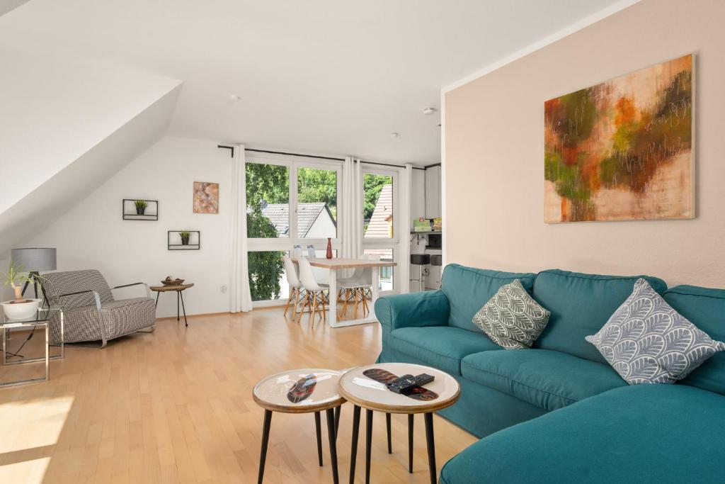 ein Wohnzimmer mit einem blauen Sofa und einem Tisch in der Unterkunft CASSEL LOFTS - Idyllische Maisonette-Wohnungen nähe Bergpark Wilhelmshöhe in Kassel