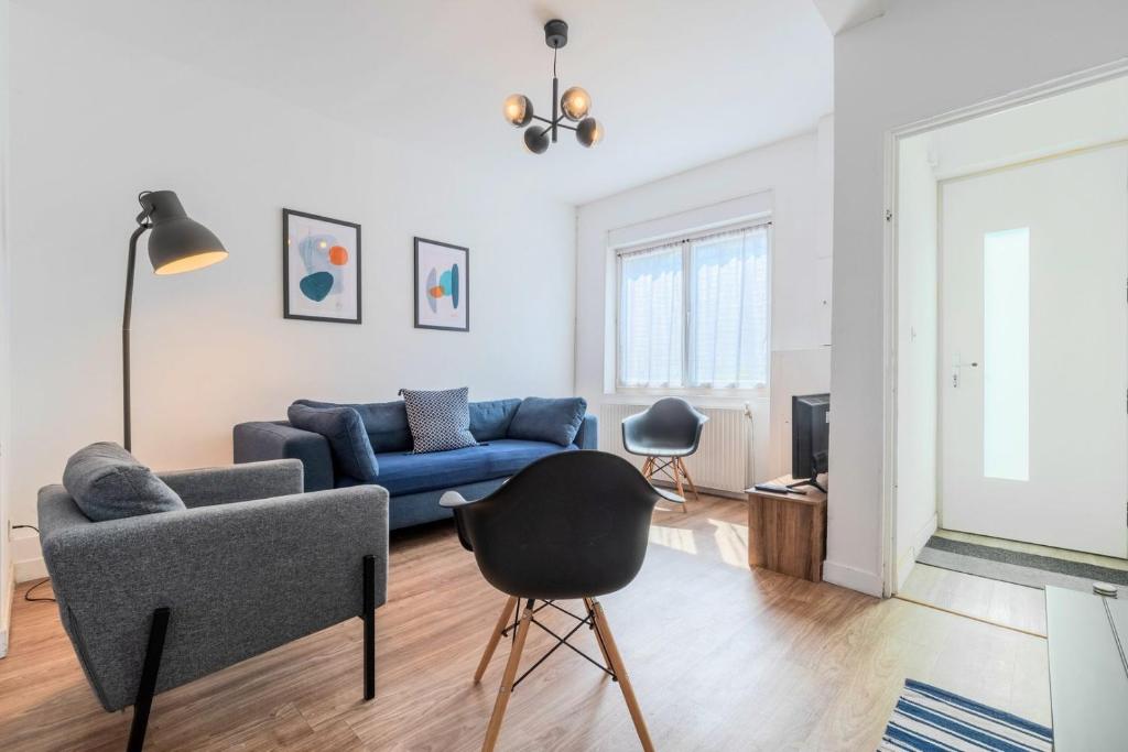 sala de estar con sofá azul y silla en Roubaix - Beautiful 4 bedrooms house with terrace!, en Roubaix