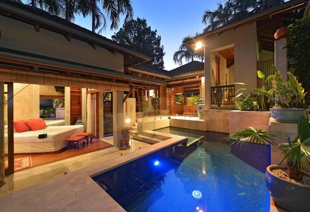 a house with a swimming pool in front of a house at Paradiso Pavilion - An Intimate Bali-style Haven in Port Douglas