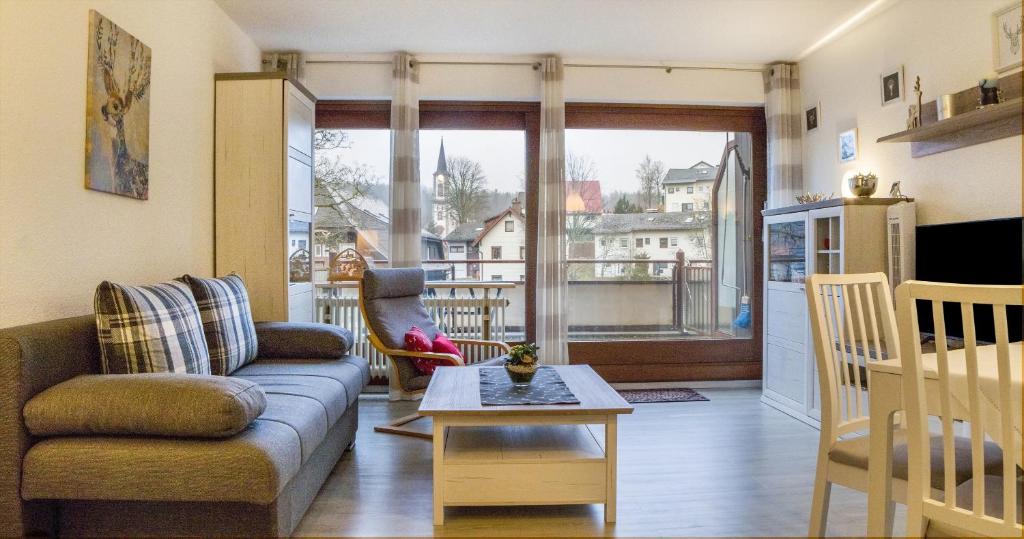 una sala de estar con un sofá y una mesa en Ferienwohnung 109 Schwarzwald, en Schönwald