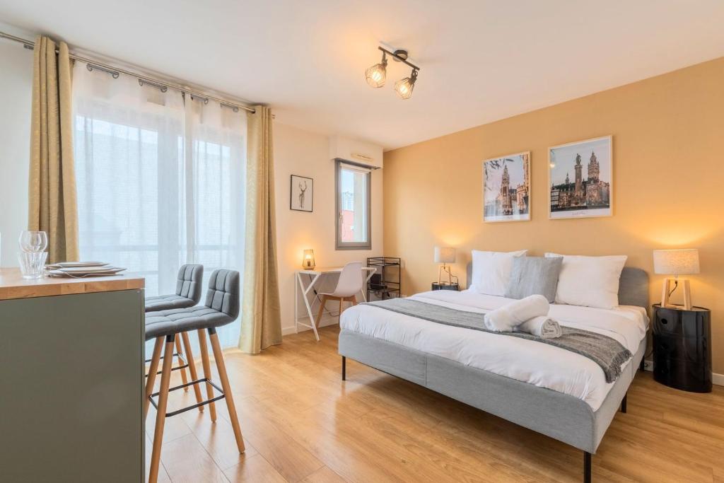 a bedroom with a bed and a table and chairs at Lille Hypercentre equipped studio for 2 people! in Lille