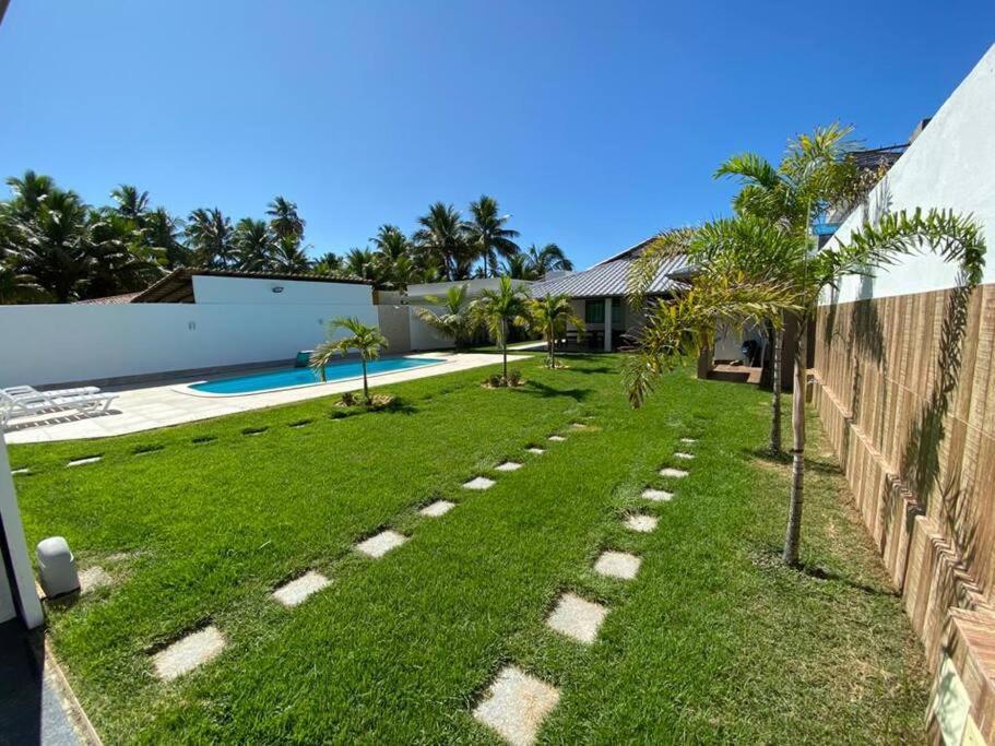 un patio trasero con césped y piscina en Casa de Excelente Padrão, COND. ÁGUAS DE OLIVENÇA en Olivença