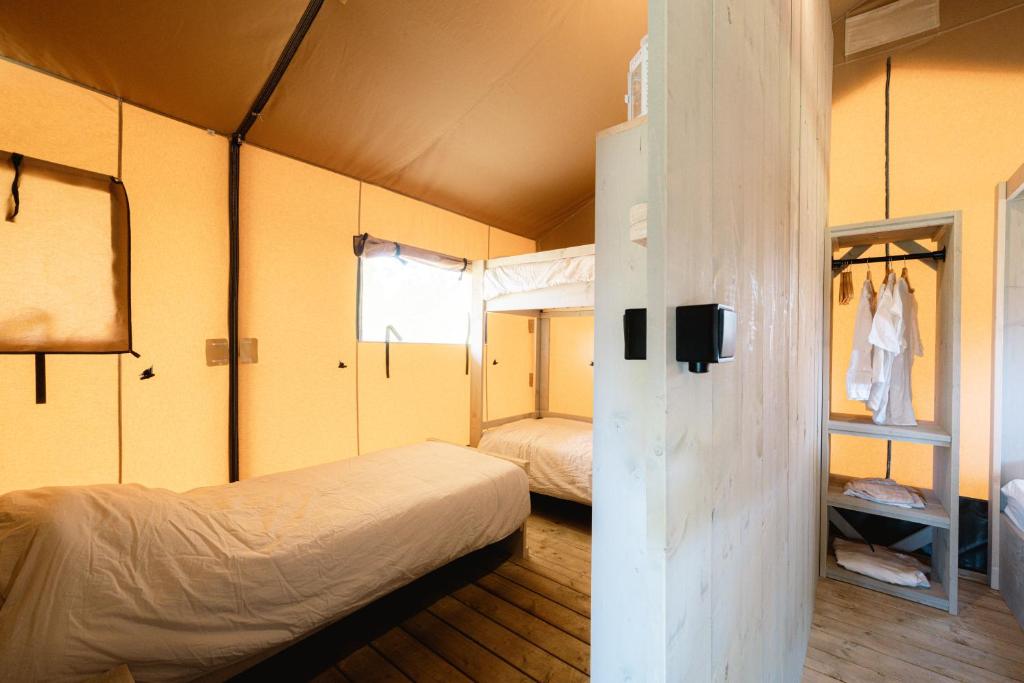 1 Schlafzimmer mit 2 Betten in einem Zimmer mit gelben Wänden in der Unterkunft Glampingzelt Family - Lodge in Soltau
