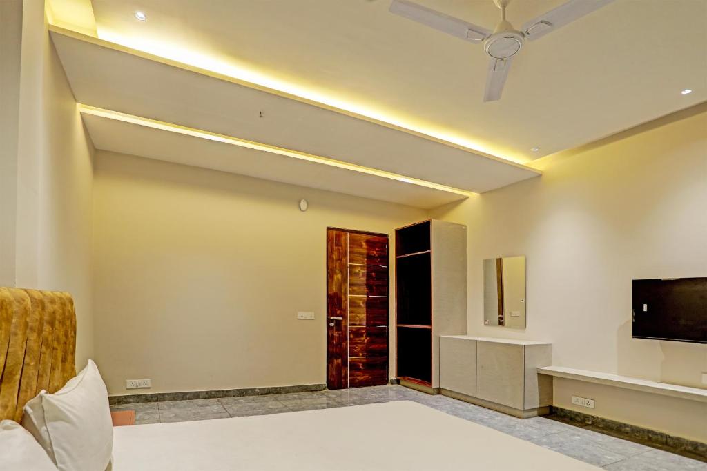a bedroom with a ceiling fan and a tv at OYO Miraas Hotel And Banquet Hall in Ludhiana