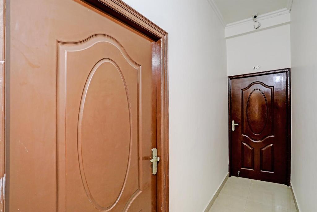 uma porta de madeira num quarto com um corredor em OYO Taj Guest House em Zirakpur