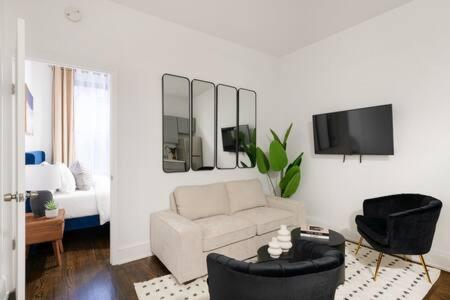a living room with a white couch and a tv at 91-2A Stylish 3BR 2Bth with W D in New York