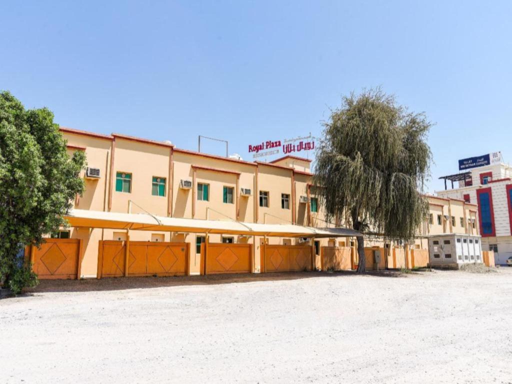 un edificio con puertas naranjas en un aparcamiento en OYO Royal Plaza Residence -3, en Ras al Khaimah