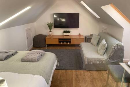 a living room with two beds and a flat screen tv at Green Glades Annex by StayStaycations in Bristol