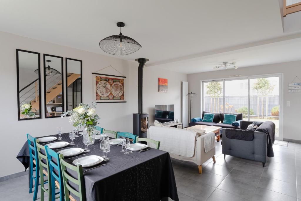 une salle à manger avec une table et un salon dans l'établissement Rosamaris - Maison pour 8 avec jardin, à Saint-Malo