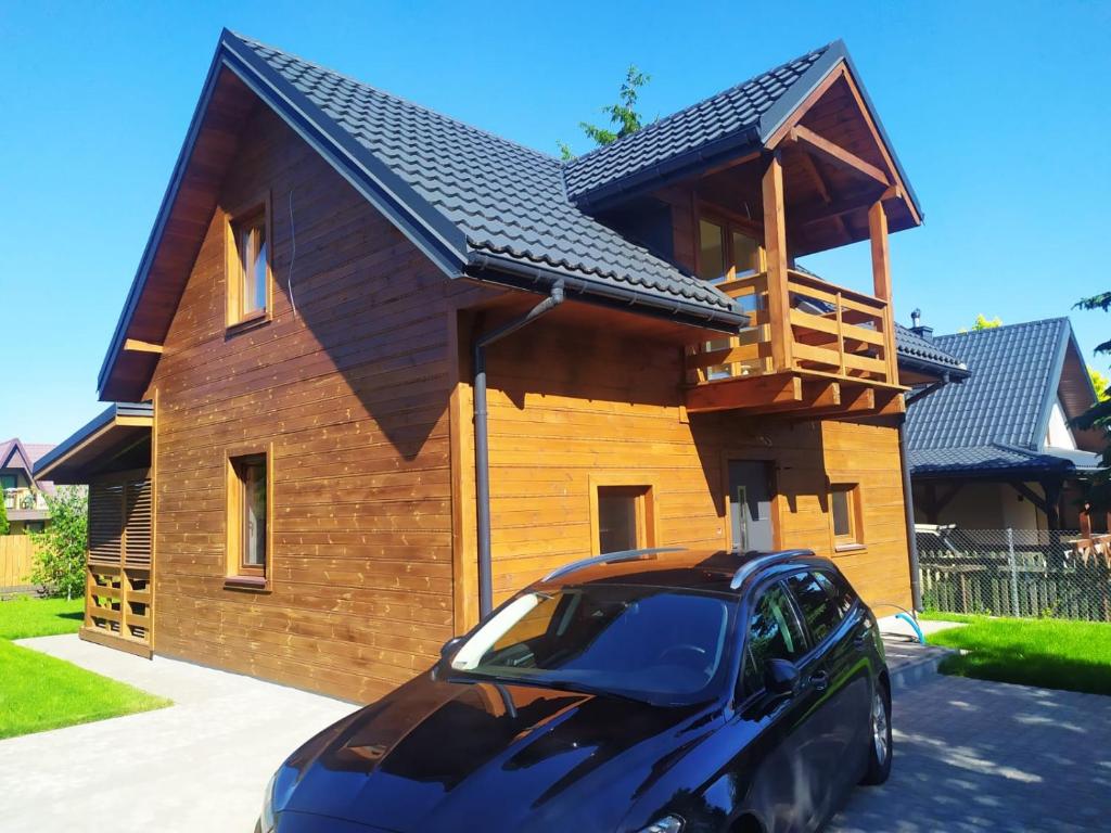 dom z samochodem zaparkowanym przed nim w obiekcie Słoneczna Polana nad Biebrzą w mieście Goniadz
