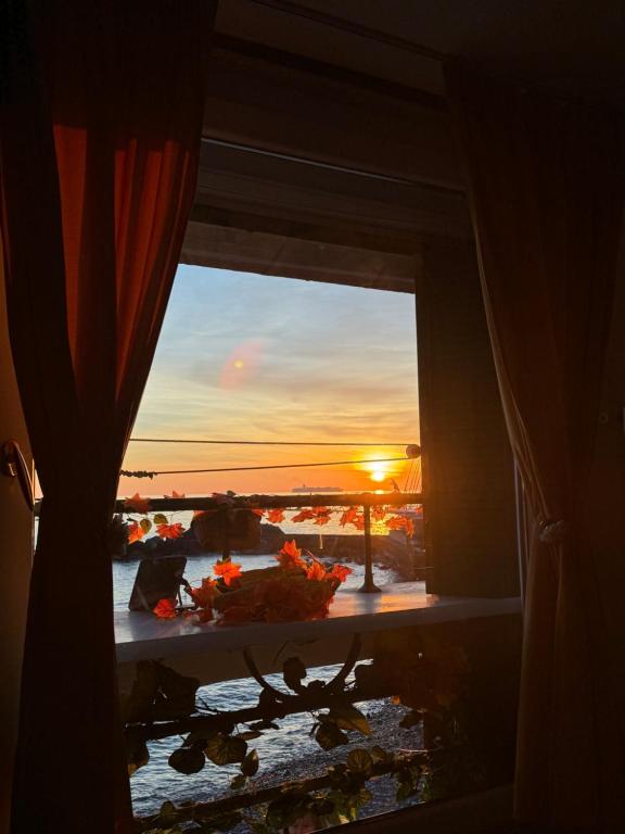 una ventana con vistas a la puesta de sol desde una habitación en Casa Bruna by Farris & Cors en Génova