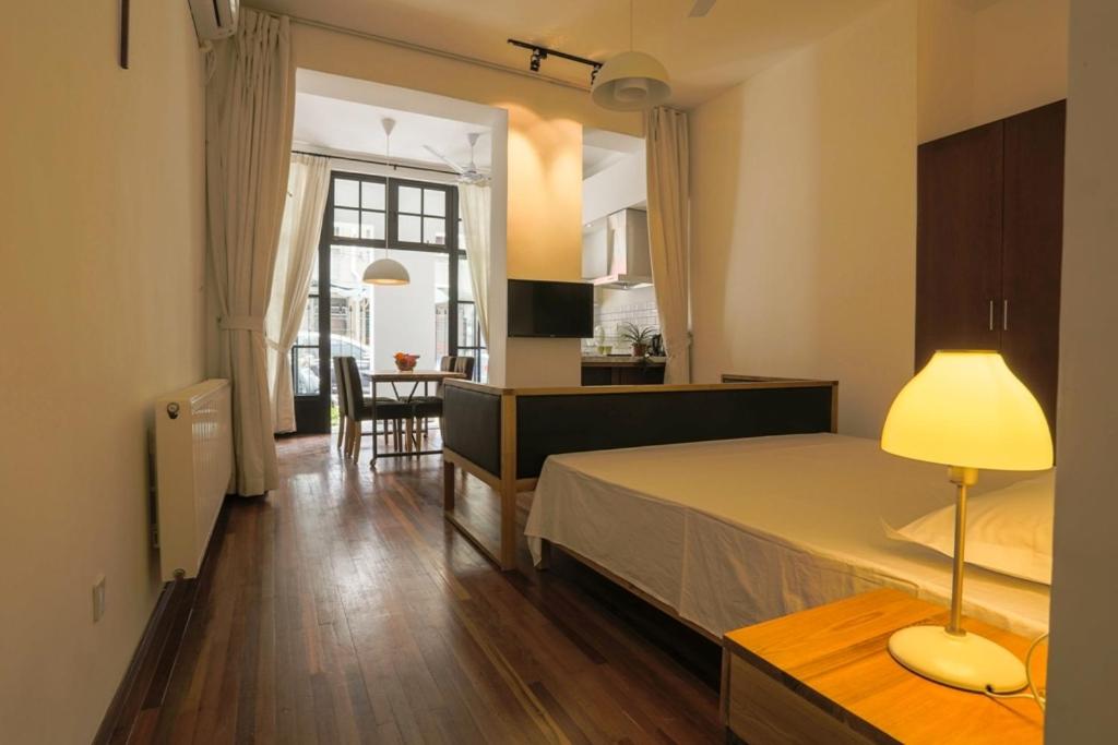 a bedroom with a bed and a kitchen and a table at Shanghai Lane 里弄公寓 in Shanghai