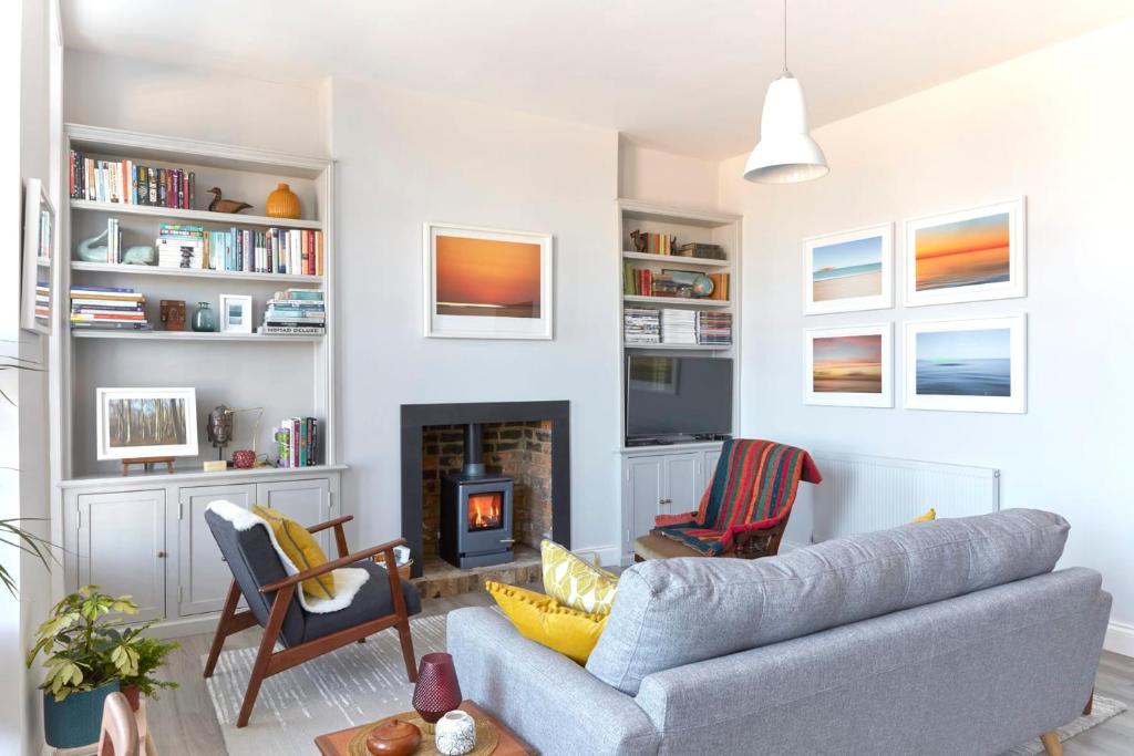 a living room with a couch and a fireplace at Spacious beach front apartment with stunning sea views in Deal