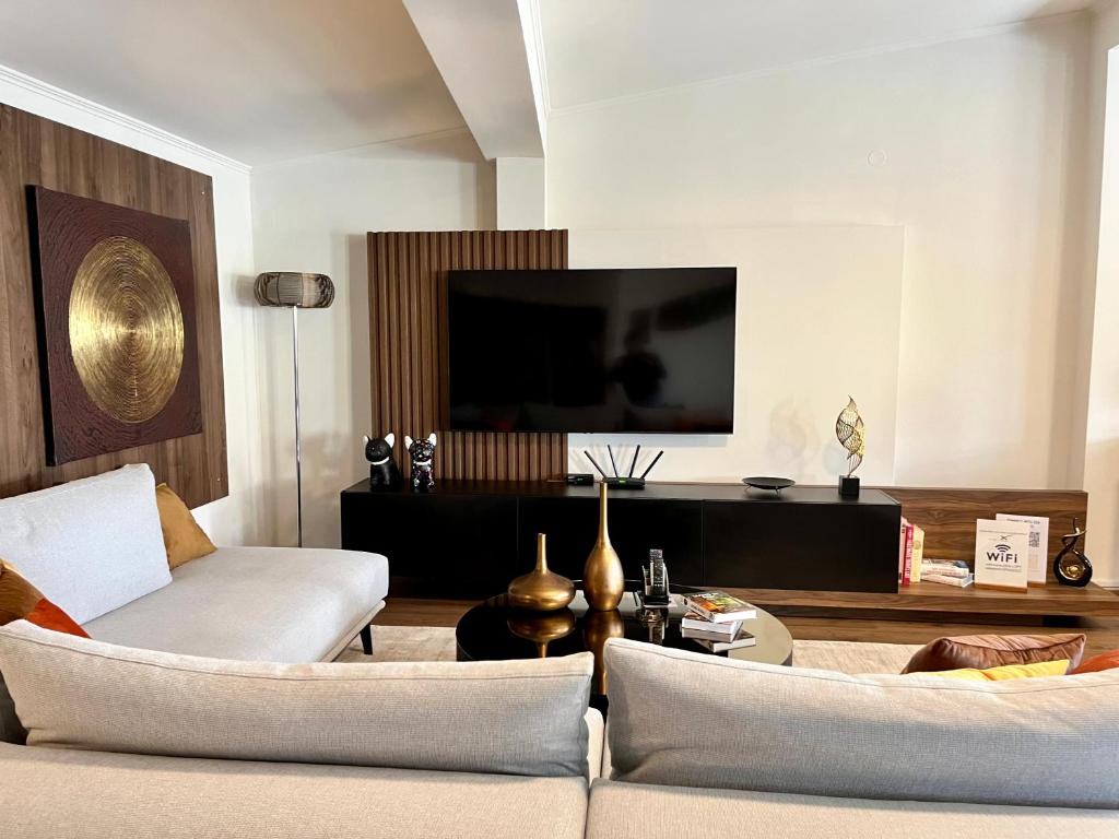 uma sala de estar com um sofá e uma televisão de ecrã plano em ZEN Apartments em Alexandroúpolis