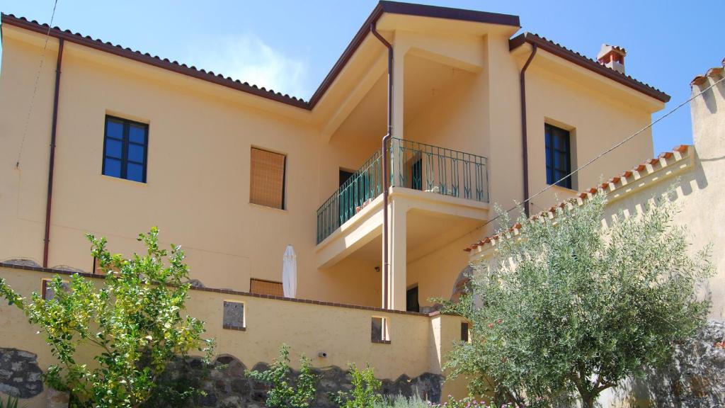 a large yellow house with a balcony at Villa Il Casale Onifai in Onifai