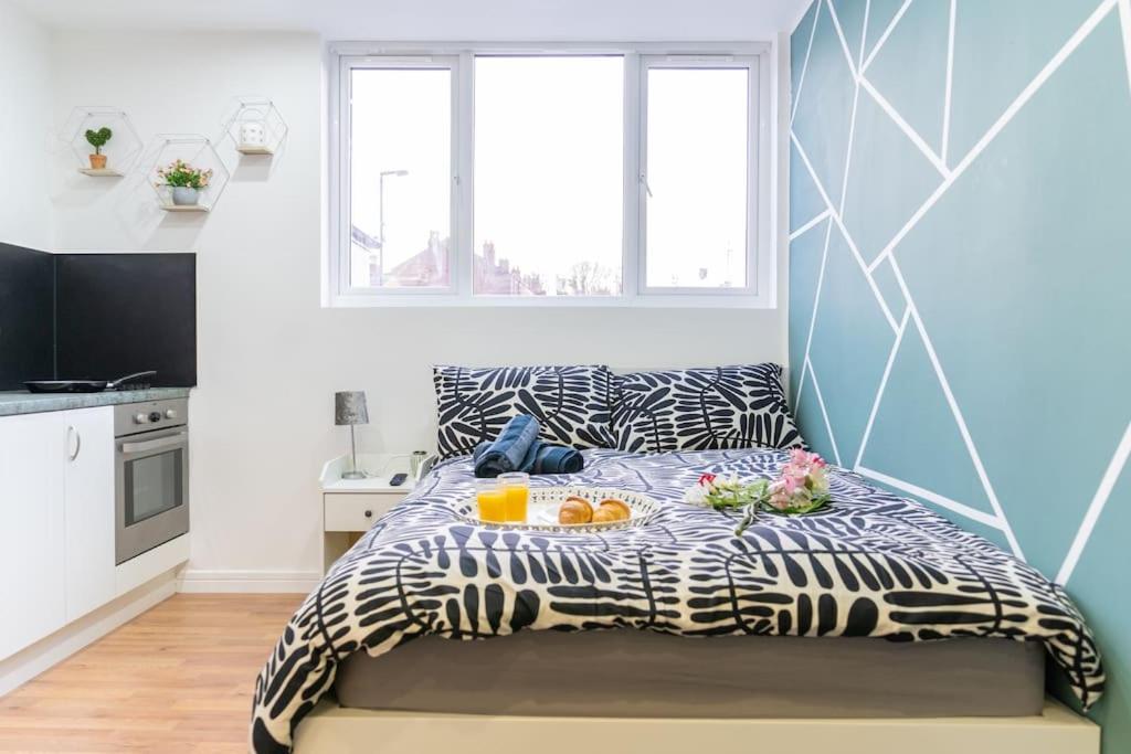 a bedroom with a bed with a tray of food on it at Urban Oasis Hideaway in Birmingham