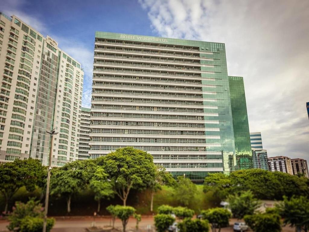 a tall building with trees in front of it at Hotel Vision Brasília - Ozped Flats in Brasilia