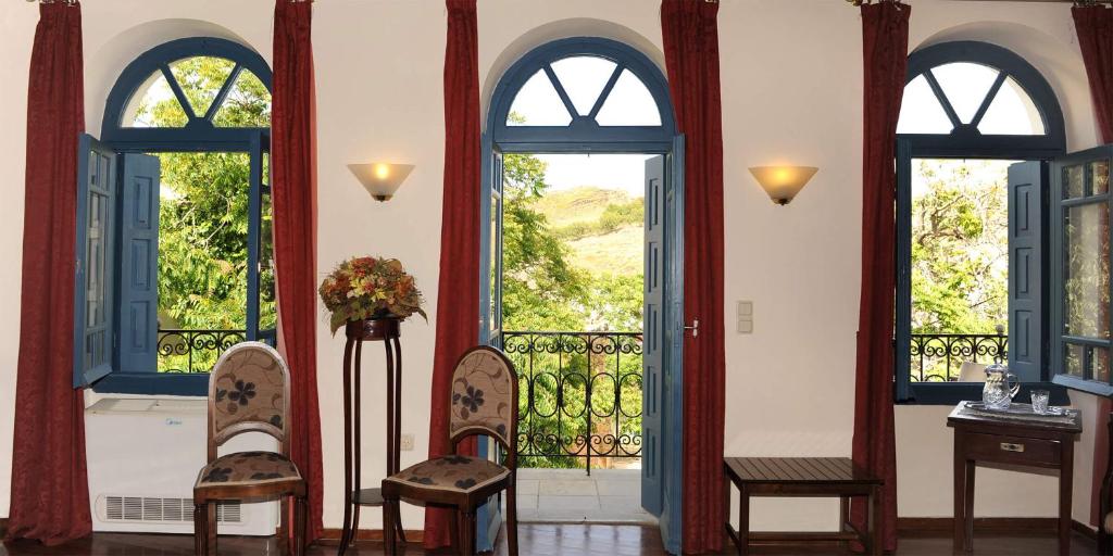 une chambre avec deux chaises et deux fenêtres dans l'établissement Villa Kynthia, à Panormos Rethymno
