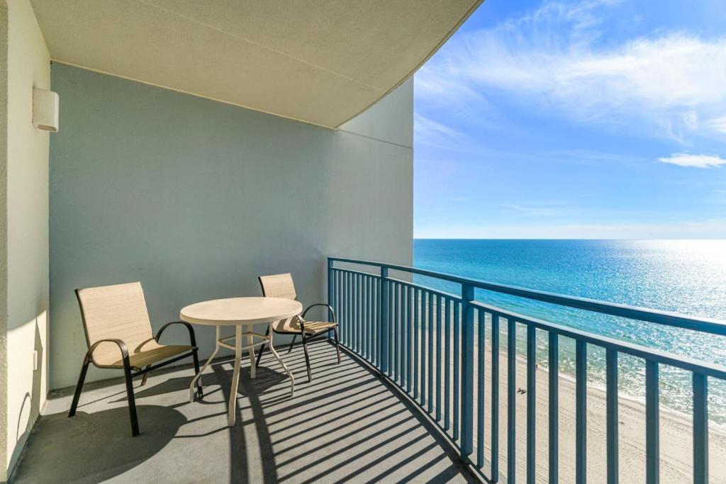 ein Balkon mit Tisch und Stühlen und dem Meer in der Unterkunft Sterling Breeze 1003 in Panama City Beach