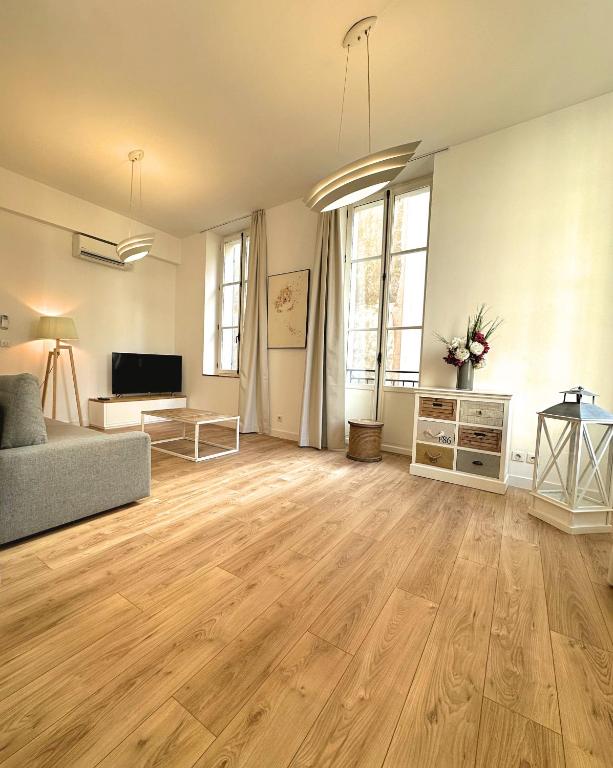 a living room with a couch and a television at Les Appartements du Vieux Port in Marseille