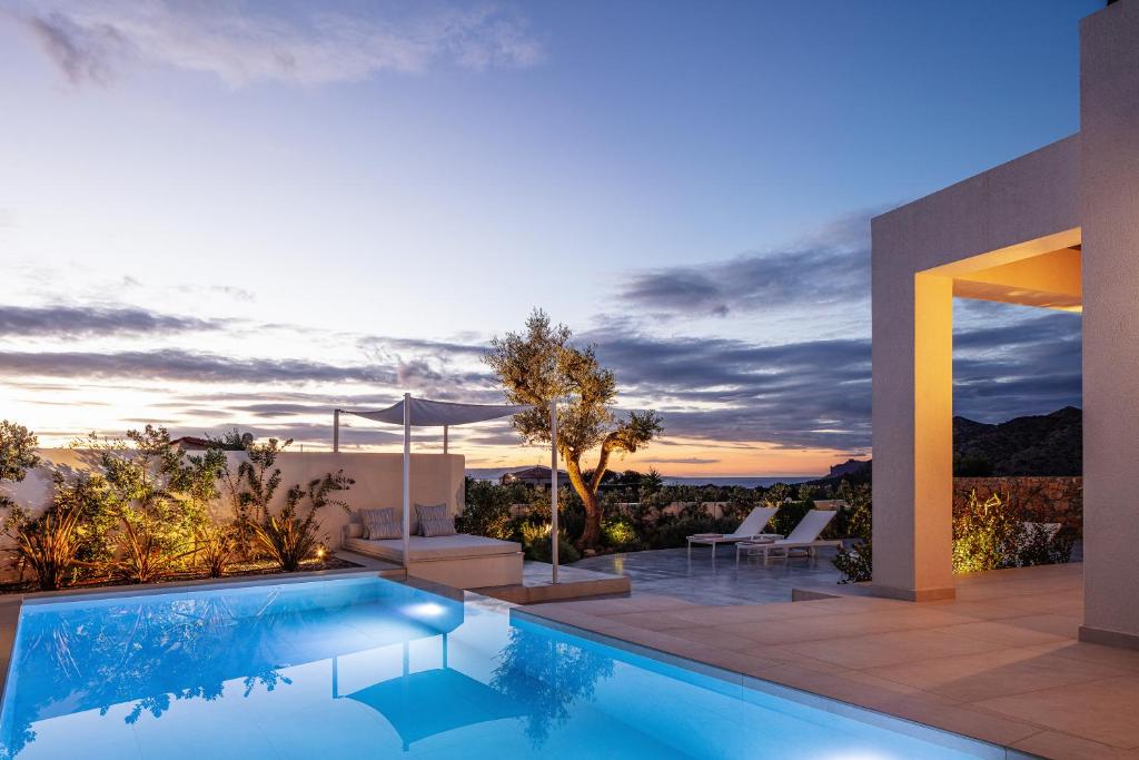 a villa with a swimming pool at dusk at Villa Venetiko - Refined Minimalist Villa with Sunset Bliss by etouri in Chania