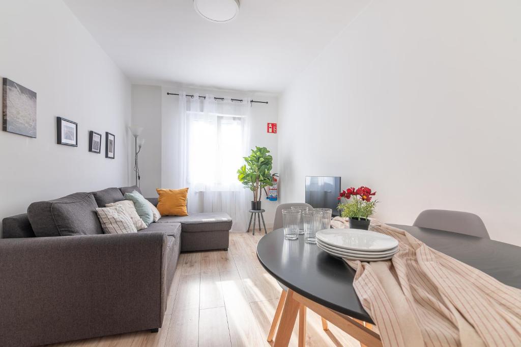 uma sala de estar com um sofá e uma mesa em Tetuan street apartment em Santander