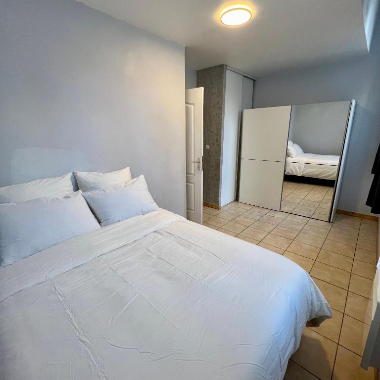 a bedroom with a white bed and a mirror at Thubaneau St Charles Canebière Vieux port in Marseille