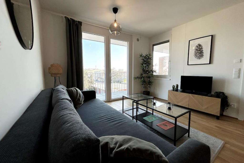 sala de estar con sofá y mesa de cristal en Stilvolle Wohnung mit Balkon, en Viena
