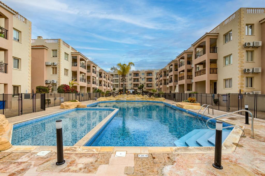 a swimming pool in a apartment complex with buildings at Sunny View - A Stunning Apartment With Private Rooftop in Paphos