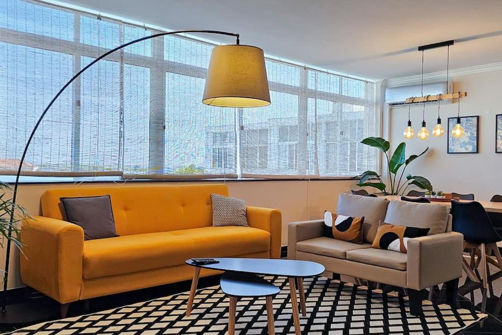 a living room with a yellow couch and a table at Sweet Formosa View in Faro